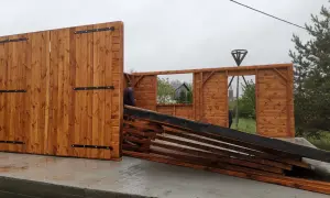 Drewniana konstrukcja, która może stać się budynkiem, jest w trakcie montażu. Widać fragmenty ścian i drzwi.