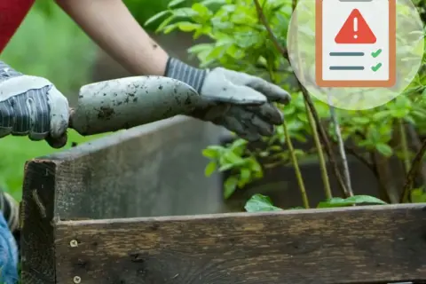 Ręce w rękawiczkach przygotowują ziemię do nawożenia roślin. Obok symbol ostrzeżenia i zielone znaczniki.