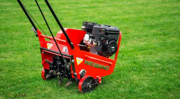 Czerwony aerator Weidemann z silnikiem Briggs & Stratton gotowy do pracy. Urządzenie zapewnia doskonałą wertykulację trawy, napowietrzając ją i usuwając filc.