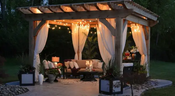 Urocza pergola z oświetleniem i zasłonami, idealna na letnie wieczory. Inspiracja, jak zrobić pergole, by stworzyć przytulne miejsce.